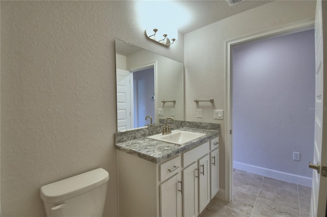 bathroom with toilet, tile patterned floors, and vanity