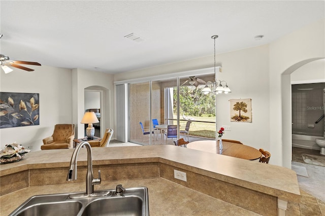 kitchen featuring ceiling fan with notable chandelier, sink, and hanging light fixtures