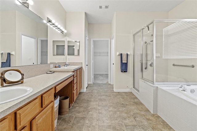 bathroom with tile patterned floors, vanity, and shower with separate bathtub