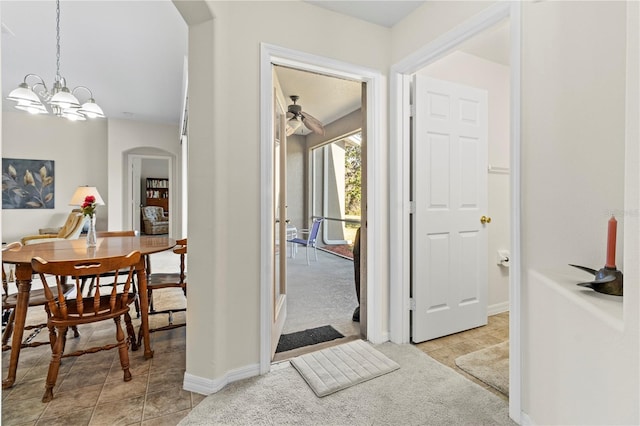 hall featuring light colored carpet and a chandelier