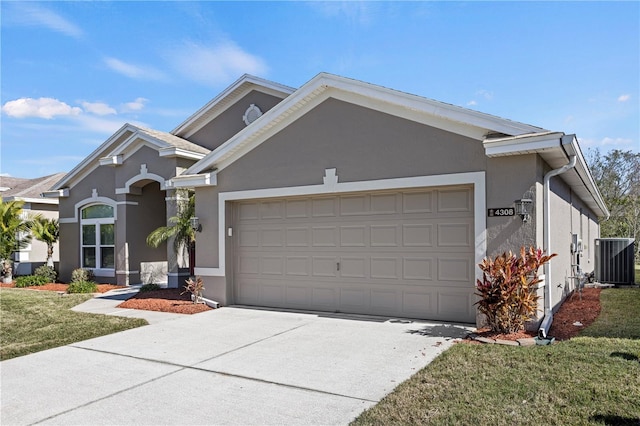 view of front of house featuring a garage, central AC unit, and a front lawn