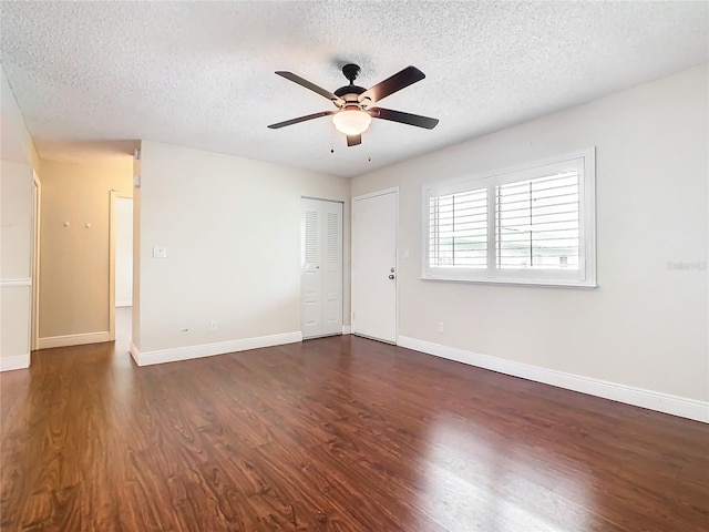 unfurnished room with ceiling fan, dark hardwood / wood-style flooring, and a textured ceiling