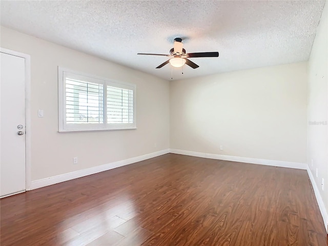 spare room featuring ceiling fan, dark wood-type flooring, and a textured ceiling