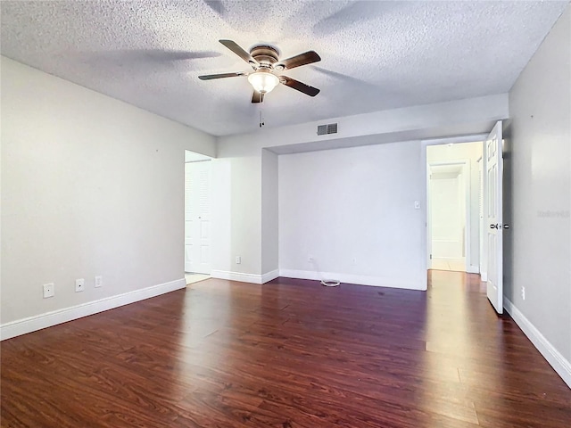 unfurnished room with ceiling fan, dark wood-type flooring, and a textured ceiling