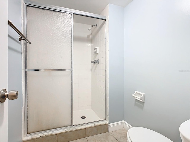 bathroom with toilet, tile patterned floors, and an enclosed shower