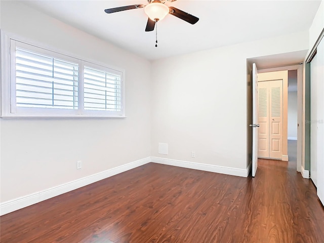 empty room featuring ceiling fan and dark wood-type flooring