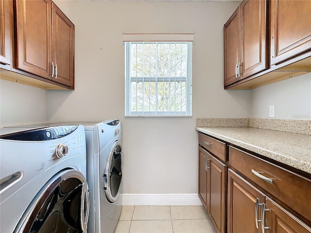 laundry room featuring cabinets, washer and clothes dryer, and light tile patterned flooring