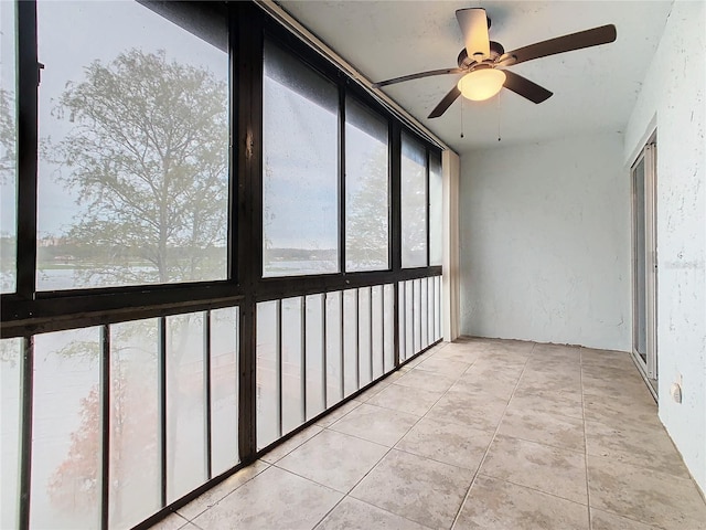 unfurnished sunroom featuring ceiling fan