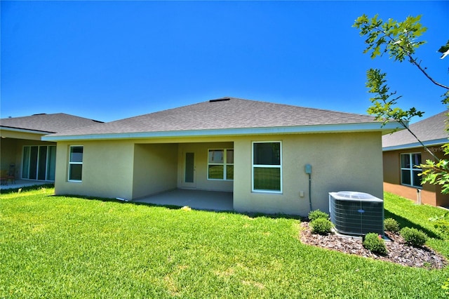 rear view of house with a patio area, cooling unit, and a yard