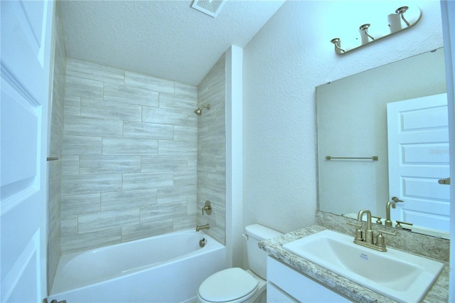 full bathroom with a textured ceiling, toilet, vanity, and tiled shower / bath combo