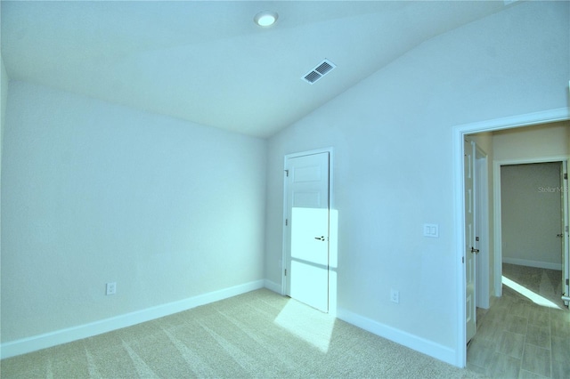 unfurnished bedroom featuring carpet and vaulted ceiling