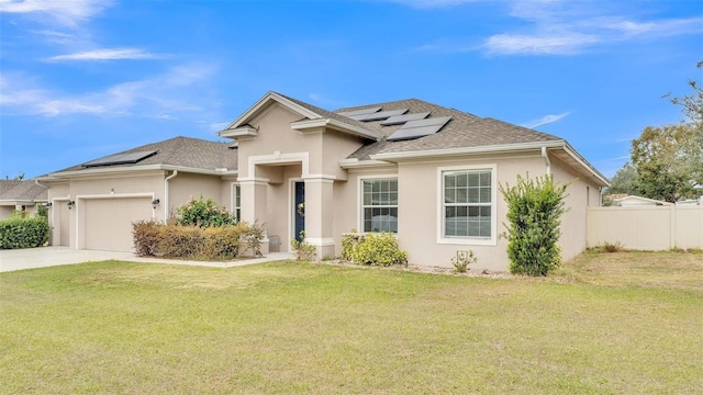 view of front of home with a front yard, solar panels, and a garage