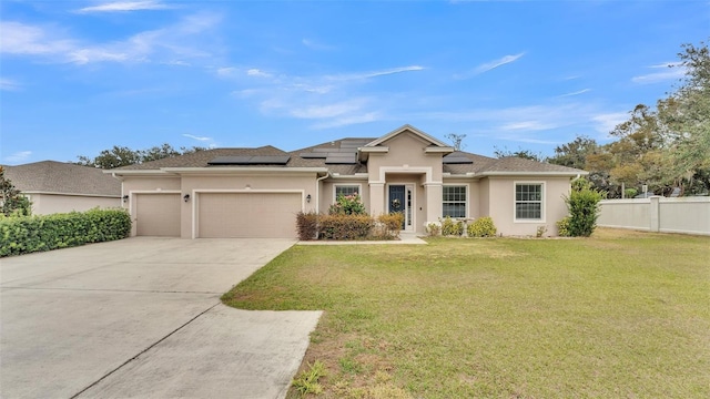 view of front of home featuring a garage, a front lawn, and solar panels