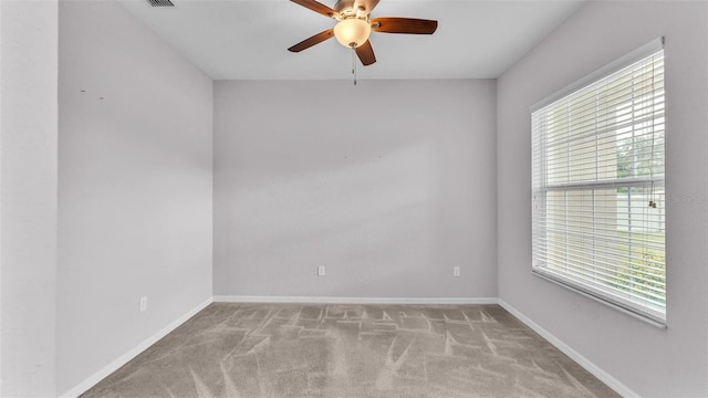 carpeted empty room featuring ceiling fan and a healthy amount of sunlight