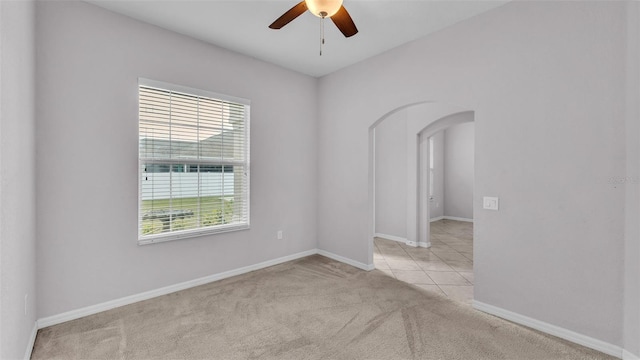 carpeted spare room featuring ceiling fan