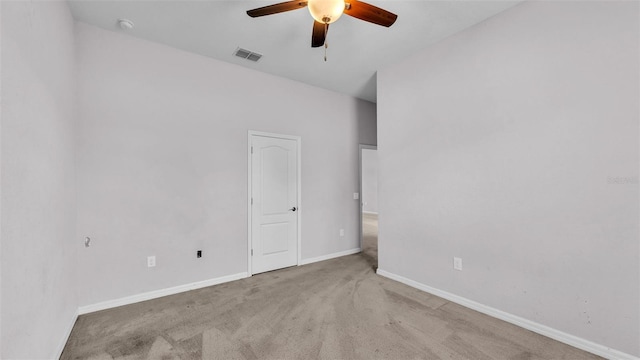 empty room featuring ceiling fan and light colored carpet