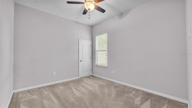 empty room with ceiling fan and light colored carpet