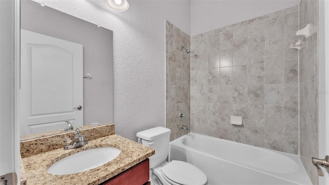 full bathroom featuring tiled shower / bath combo, vanity, and toilet