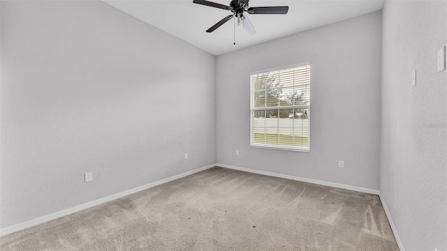 empty room featuring ceiling fan and carpet