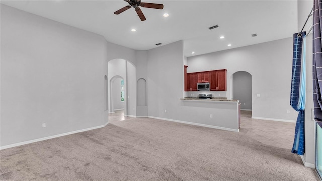 212 Kissengen Park Dr, Bartow, FL 33830 - unfurnished living room featuring light colored carpet, arched walkways, ceiling fan, recessed lighting, and baseboards