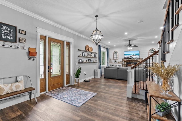 entrance foyer featuring crown molding, dark hardwood / wood-style flooring, ceiling fan with notable chandelier, and a textured ceiling