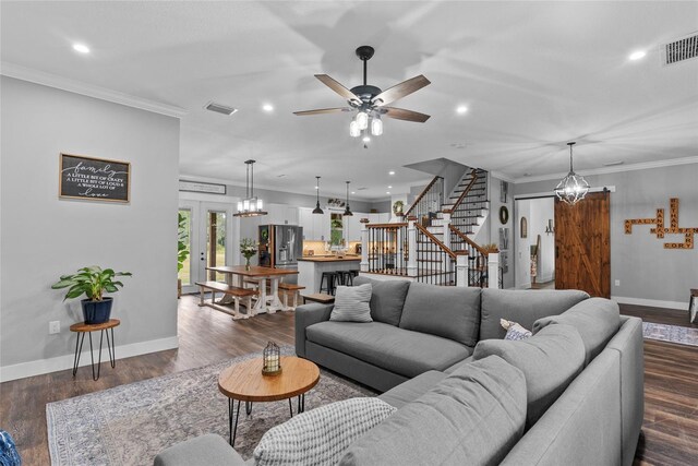 living room with ceiling fan with notable chandelier, dark hardwood / wood-style flooring, ornamental molding, and french doors