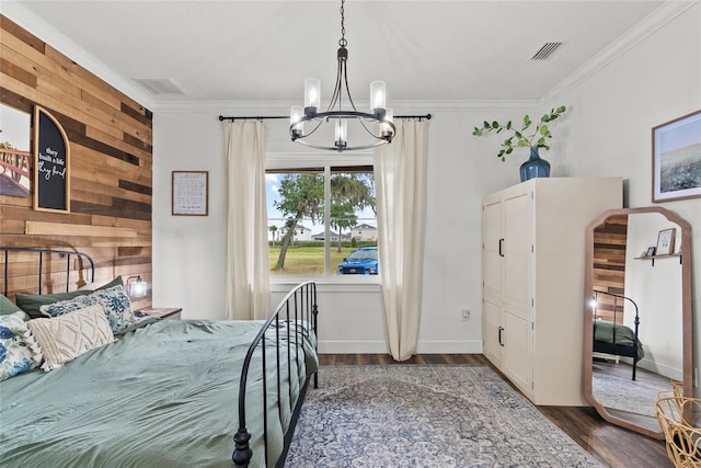 bedroom featuring crown molding, dark hardwood / wood-style floors, wood walls, and an inviting chandelier