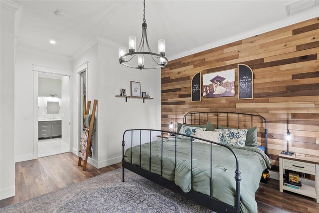 bedroom featuring wooden walls, a notable chandelier, ensuite bath, dark wood-type flooring, and ornamental molding