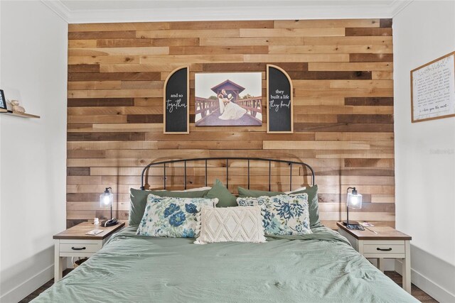 bedroom featuring ornamental molding and wood walls