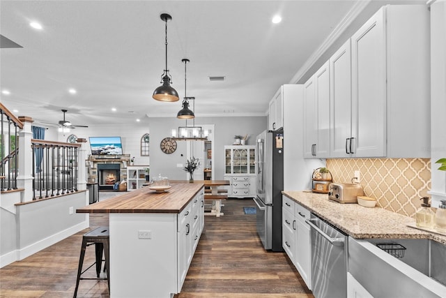 kitchen featuring pendant lighting, a center island, white cabinetry, a breakfast bar area, and stainless steel appliances