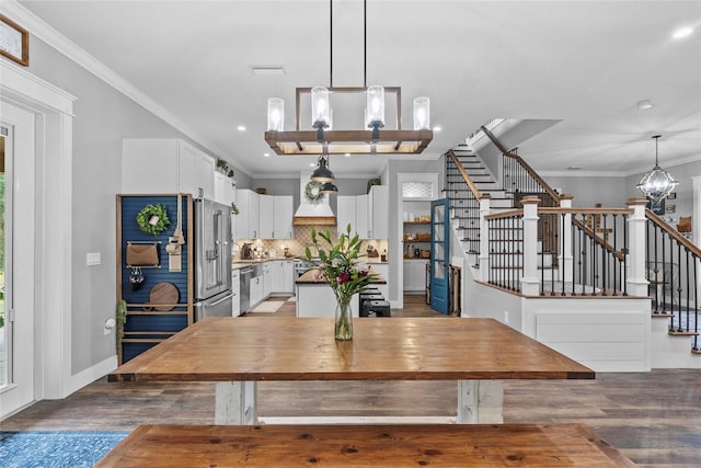 dining room with a chandelier, crown molding, and light hardwood / wood-style floors