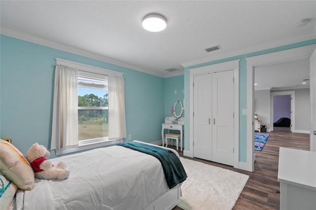 bedroom with dark wood-type flooring, a closet, and ornamental molding