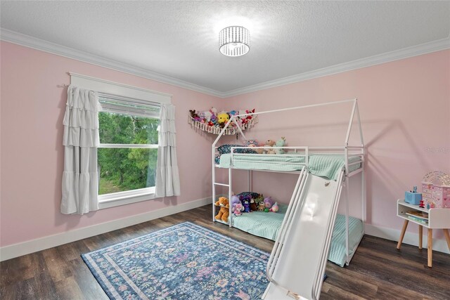 bedroom with dark wood-type flooring, ornamental molding, and a textured ceiling