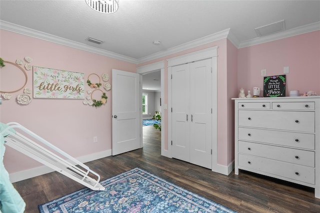 bedroom featuring a closet, dark hardwood / wood-style flooring, ornamental molding, and a textured ceiling