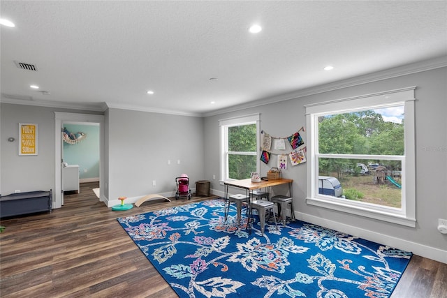 game room featuring a textured ceiling, dark hardwood / wood-style flooring, and crown molding