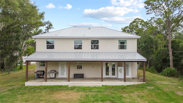 rear view of property featuring french doors, a yard, and a patio