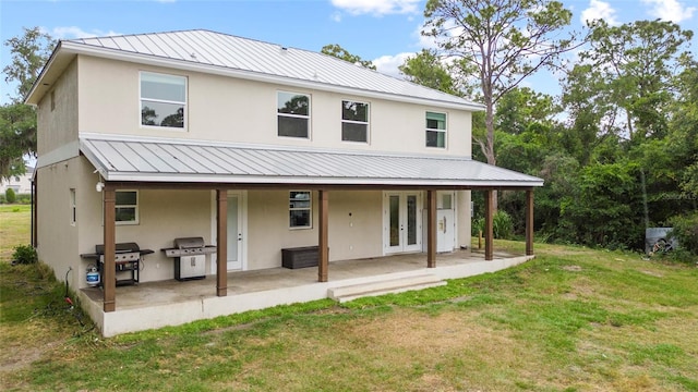 rear view of house with french doors, a patio, a yard, and area for grilling