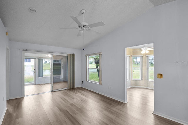 unfurnished room with vaulted ceiling, ceiling fan, a textured ceiling, and light wood-type flooring