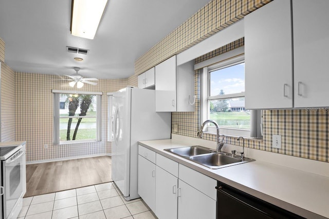 kitchen featuring sink, white appliances, white cabinets, and light tile patterned flooring