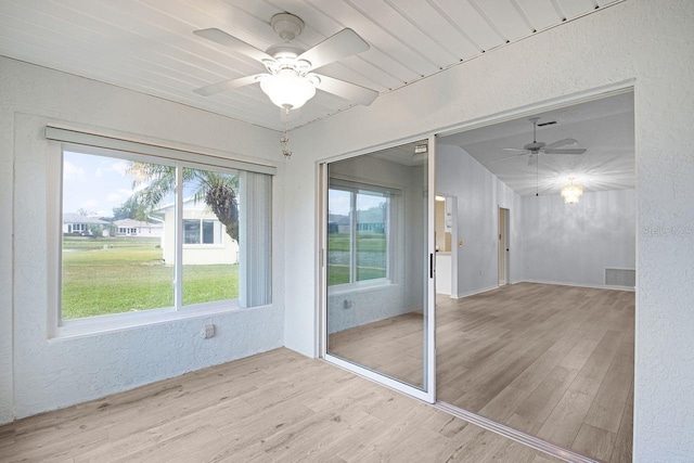 unfurnished sunroom featuring ceiling fan and a healthy amount of sunlight