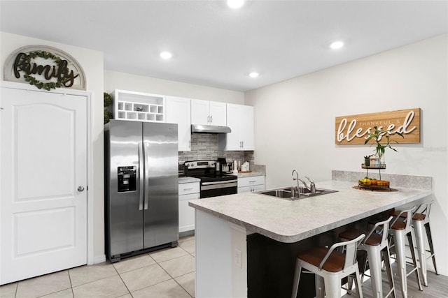 kitchen featuring sink, white cabinetry, stainless steel appliances, a kitchen bar, and kitchen peninsula