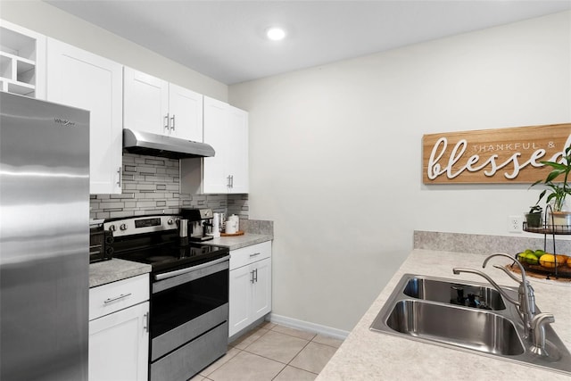 kitchen with sink, white cabinetry, stainless steel appliances, light tile patterned flooring, and decorative backsplash