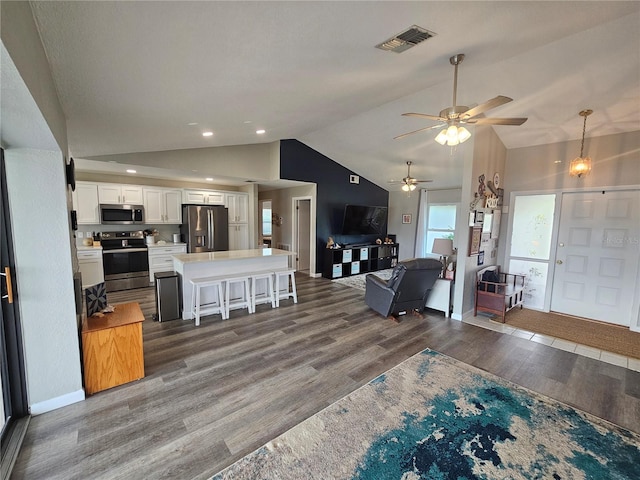 living room with lofted ceiling, ceiling fan, and dark hardwood / wood-style flooring