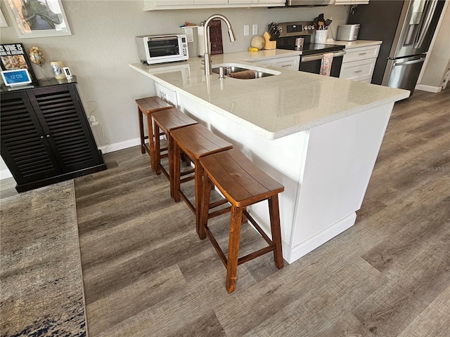 kitchen featuring stainless steel appliances, a kitchen bar, kitchen peninsula, and sink