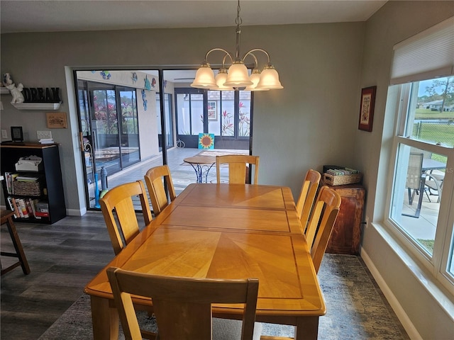 dining area with dark hardwood / wood-style flooring and a notable chandelier