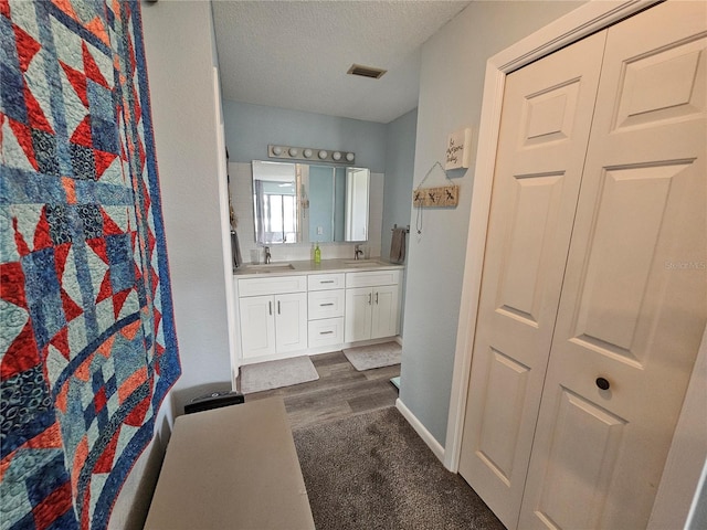 bathroom featuring vanity, wood-type flooring, and a textured ceiling