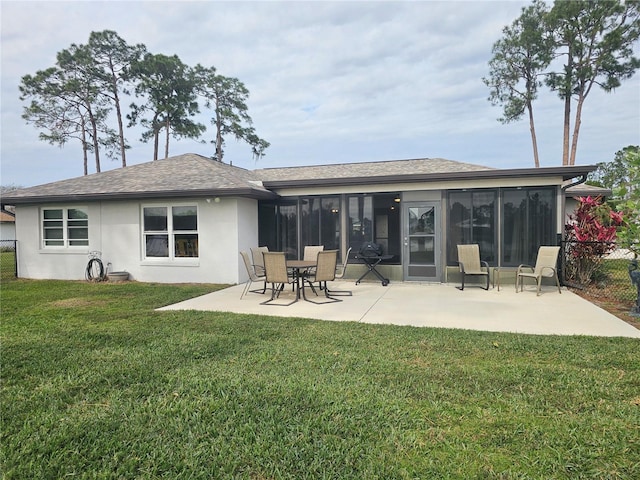 rear view of property with a sunroom, a lawn, and a patio