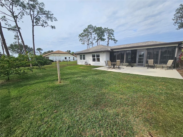 back of property with a sunroom, a yard, and a patio