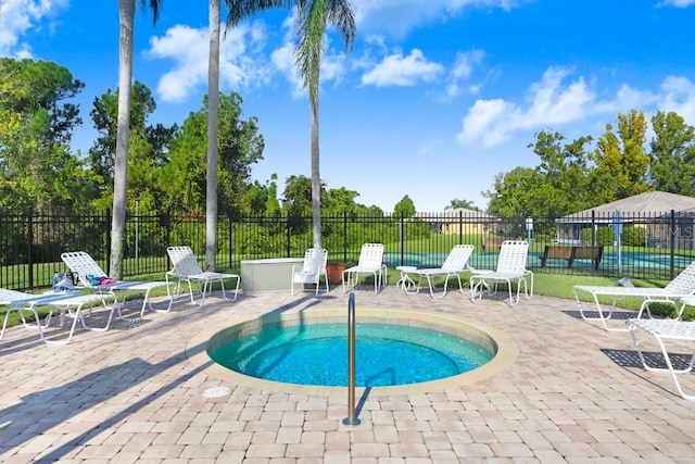 view of pool with a community hot tub and a patio