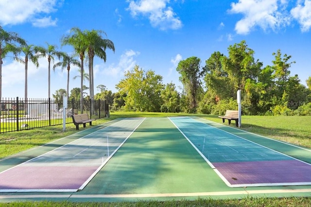 view of tennis court with a yard